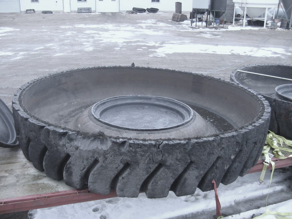 large mining tire cut in half with insert plugging the middle